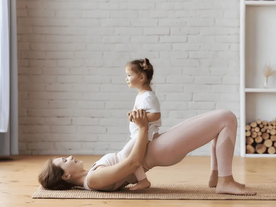 Woman doing pelvic floor exercises at home with child nearby