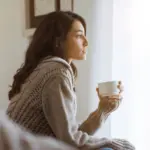Woman sitting by the window in a reflective moment