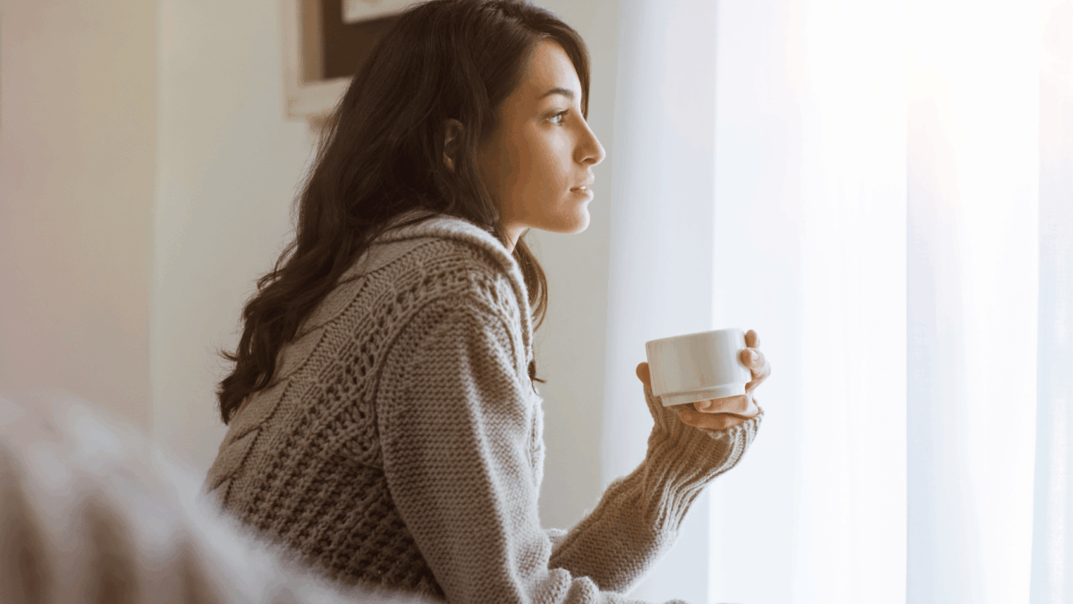 Fruchtbarkeit_steigern_Tipps_bei_Kinderwunsch_Frau_Sitzt_am_Fenster