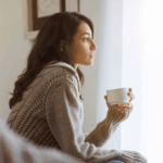 Fruchtbarkeit_steigern_Tipps_bei_Kinderwunsch_Frau_Sitzt_am_Fenster