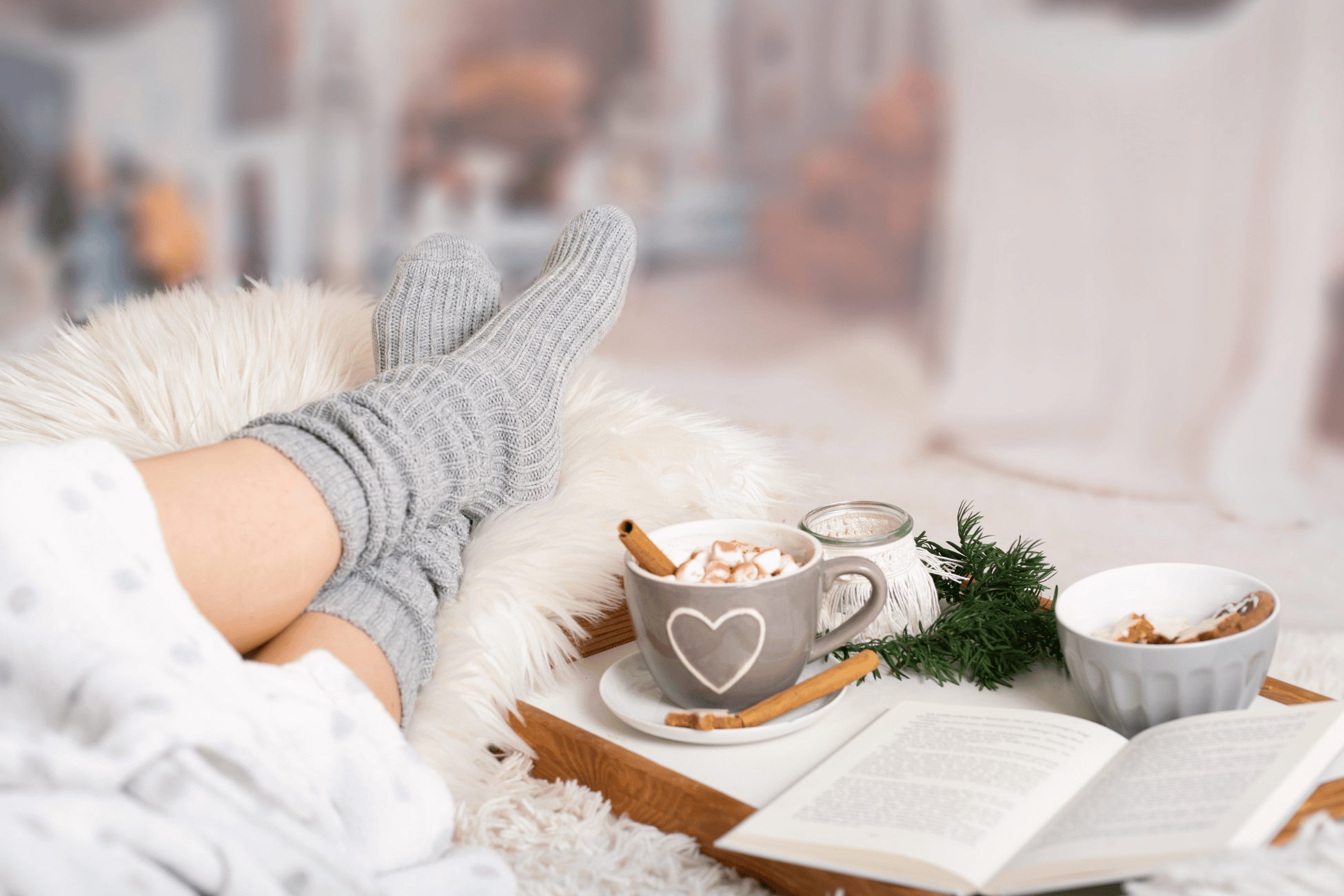 Woman on a sofa wearing cozy socks in a winter hygge setting