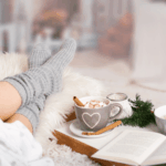 Hygge_im-Alltag,-Winter-Routine_für_Frauen,_Frau_auf_Sofa_mit_Kuschensocken_für_mehr_Wohlbefinden_im_Winter