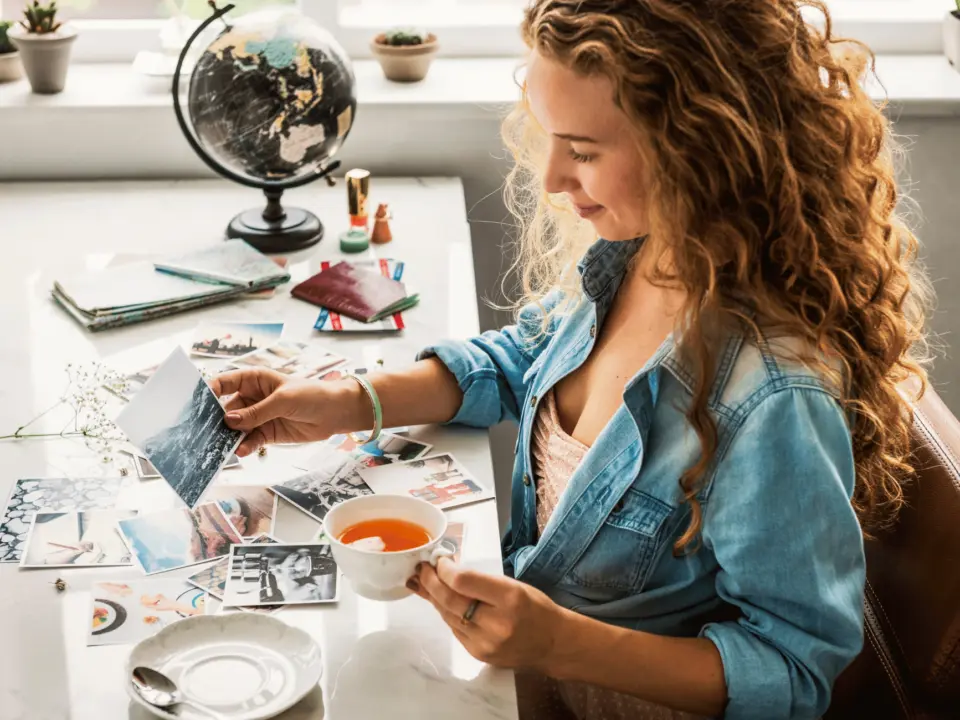 Frau gestaltet ein Vision Board mit Fotos und Notizen