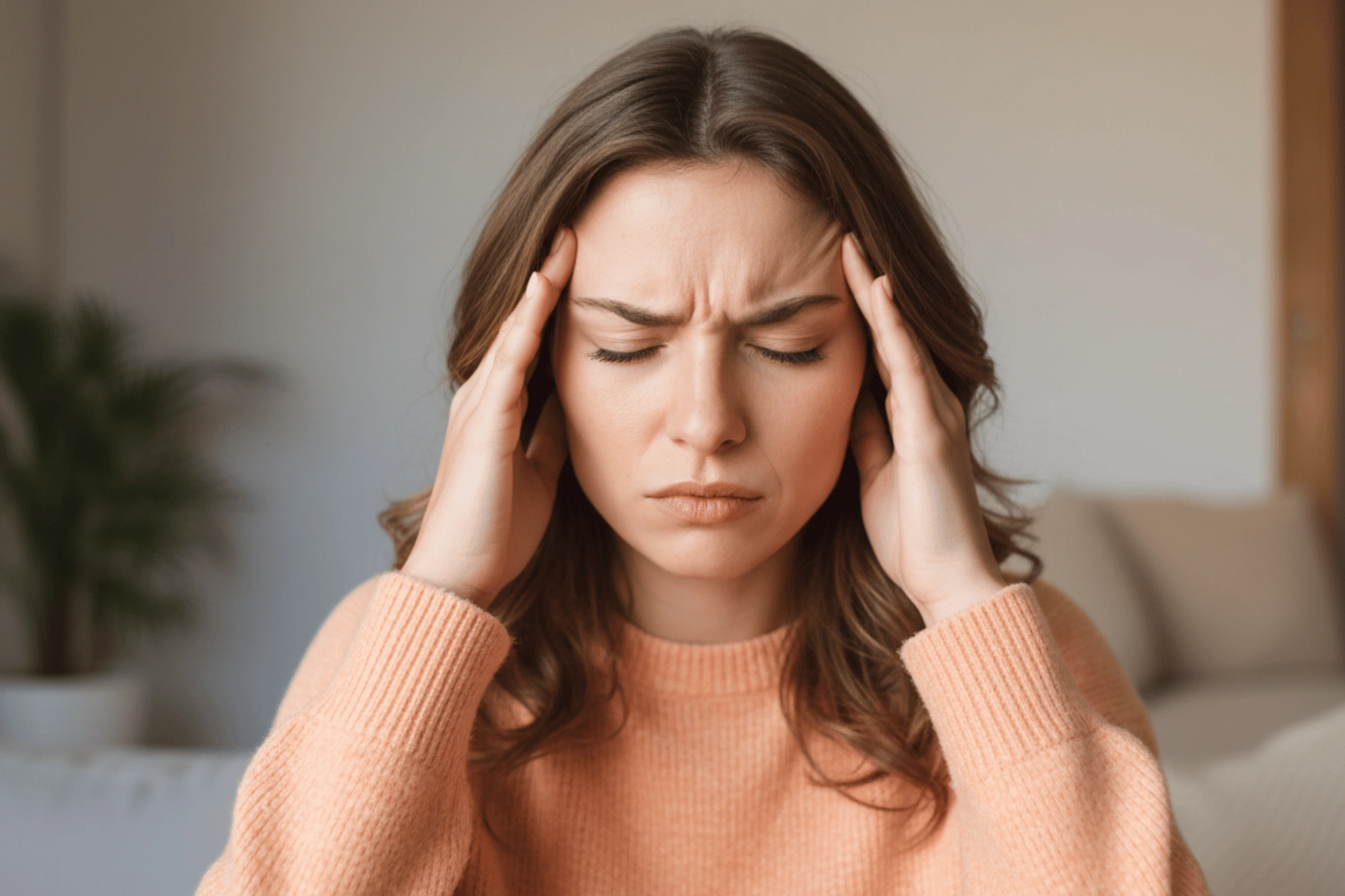 Mujer sentada con la mano en la cabeza en un momento de malestar