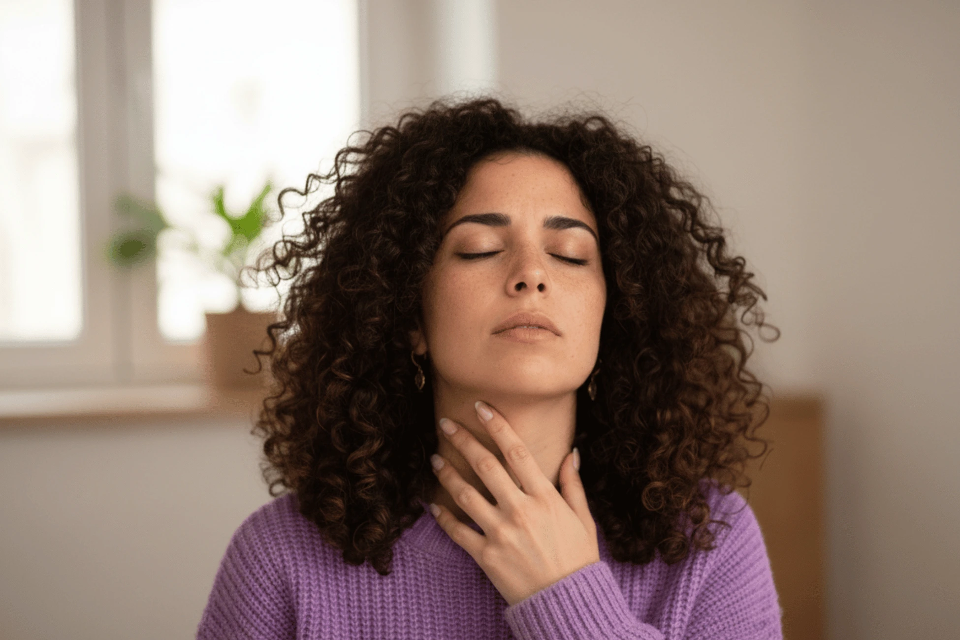 Donna con la mano sul collo in un ambiente tranquillo
