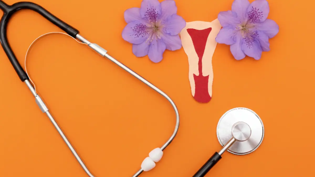 Illustration de l’utérus féminin avec flux menstruel et stéthoscope médical sur fond orange, symbolisant la santé gynécologique.