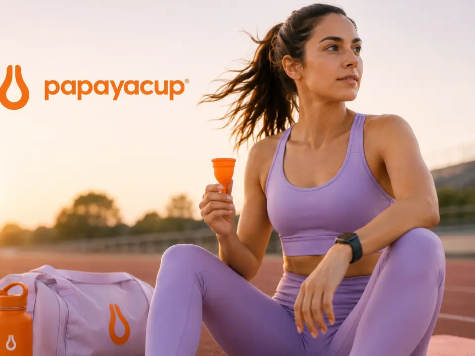 Imagen fotorealista donde se ve a una mujer deportista con ropa de deporte aguantando su copa menstrual papaya cup