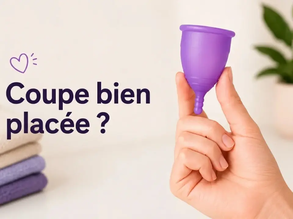 Une main tient une coupe menstruelle violette devant un texte questionnant son placement, et des linges pliés.
