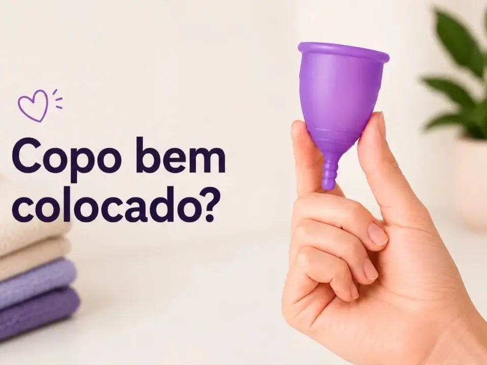 Mão segura uma copa menstrual roxa com a pergunta ¿Copa bien colocada?.